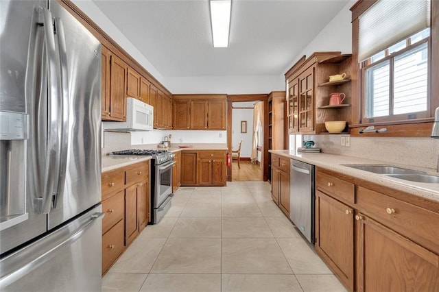 kitchen with light tile patterned floors, stainless steel appliances, and sink