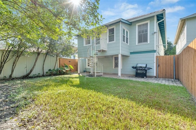 rear view of property featuring a yard and a patio