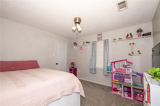 bedroom with ceiling fan, carpet floors, and a textured ceiling