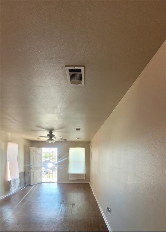 empty room featuring a textured ceiling, ceiling fan, and hardwood / wood-style floors