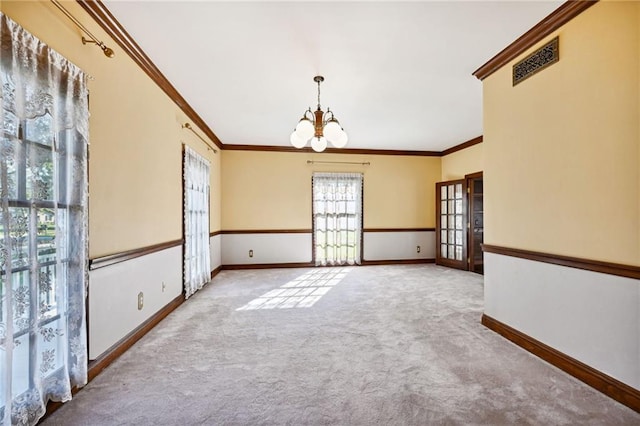 carpeted empty room with french doors, crown molding, and a chandelier