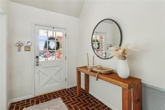 doorway featuring baseboards, brick patterned floor, visible vents, and a wealth of natural light