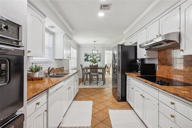 kitchen with hanging light fixtures, ornamental molding, a sink, under cabinet range hood, and black appliances