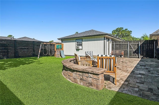 view of yard featuring an outdoor fire pit, a playground, a patio, and a fenced backyard