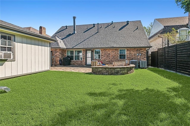 back of house with cooling unit, brick siding, fence, a lawn, and a patio area