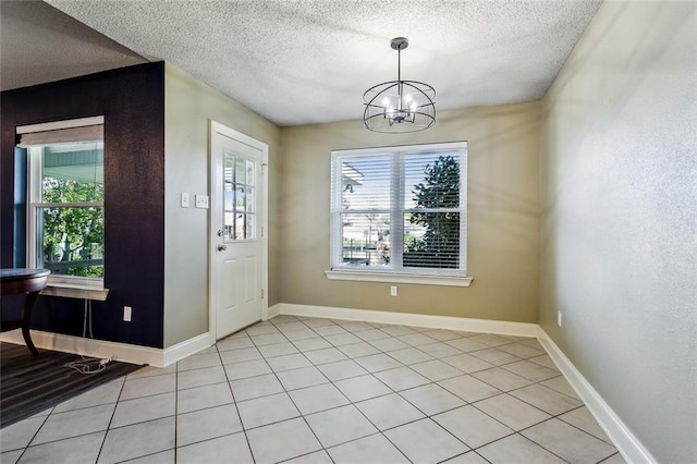 interior space with light tile patterned floors, a chandelier, and a textured ceiling