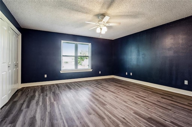 unfurnished bedroom featuring a closet, hardwood / wood-style flooring, a textured ceiling, and ceiling fan