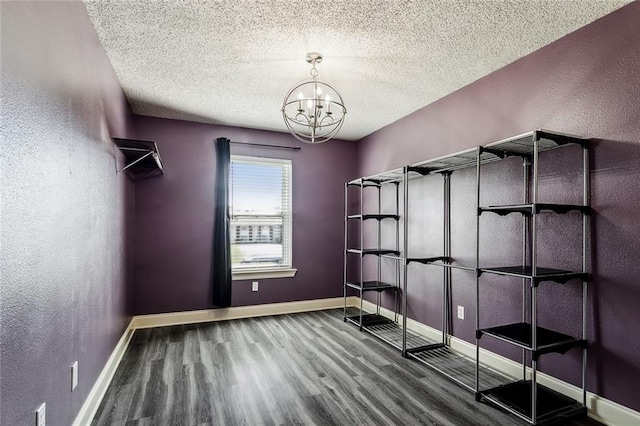 spacious closet with hardwood / wood-style floors and a notable chandelier