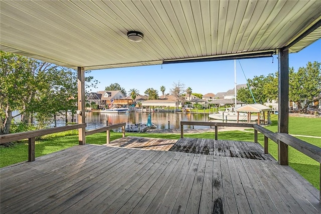 deck with a dock, a yard, and a water view