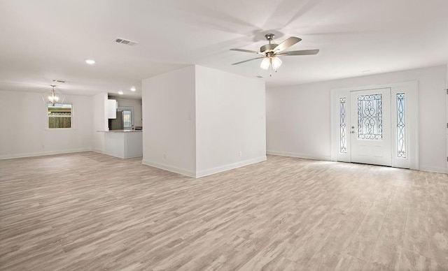 unfurnished living room featuring ceiling fan with notable chandelier and light hardwood / wood-style floors