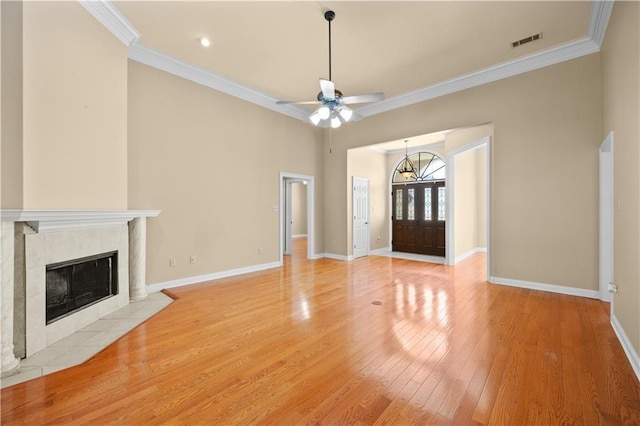 unfurnished living room with ceiling fan, a fireplace, crown molding, and light hardwood / wood-style floors