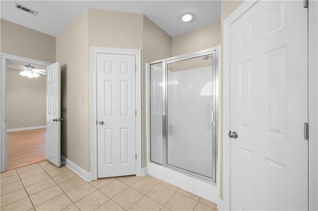 bathroom with tile patterned floors, ceiling fan, and walk in shower