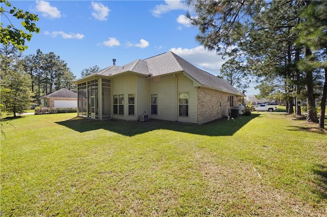 back of house featuring a yard, a sunroom, and cooling unit