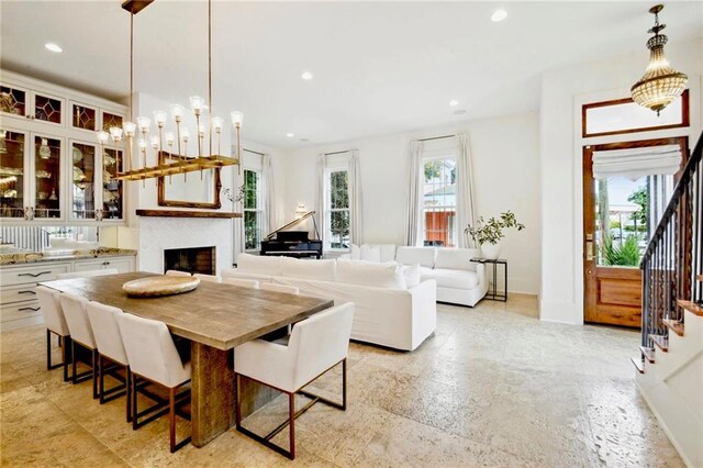 dining area featuring recessed lighting, a fireplace, stairs, and baseboards