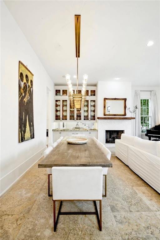 dining space with recessed lighting, a fireplace, and baseboards