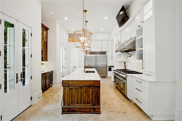 kitchen with high quality appliances, under cabinet range hood, recessed lighting, french doors, and light countertops