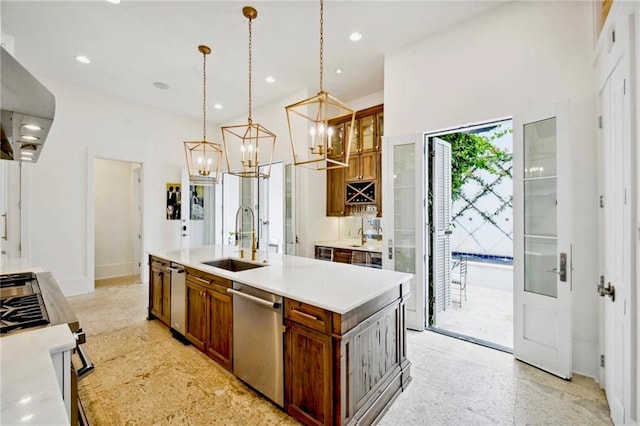 kitchen featuring light countertops, stainless steel dishwasher, gas stove, wall chimney exhaust hood, and a sink