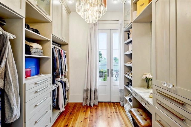 spacious closet with a notable chandelier and light wood-style floors