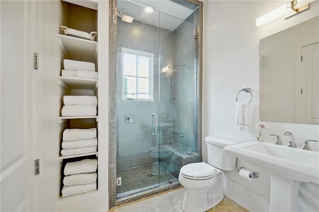 bathroom with a sink, toilet, and a shower stall