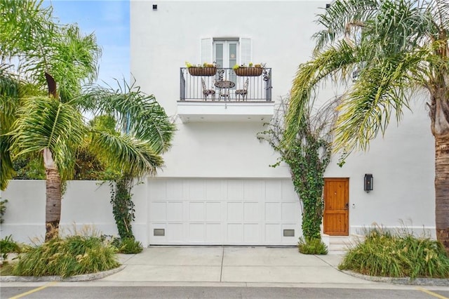 view of front of home with a garage and a balcony