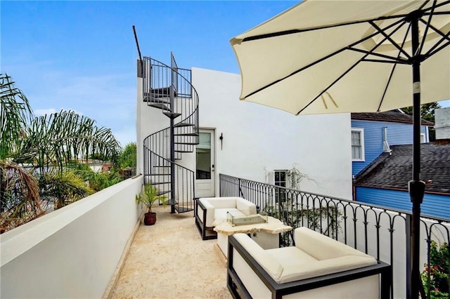 balcony featuring an outdoor living space and stairway