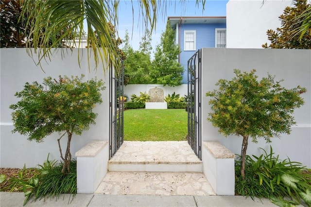 view of gate with a yard