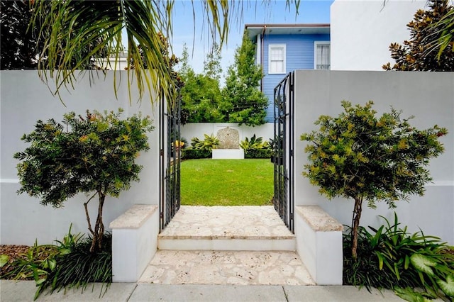 view of gate with a lawn and fence