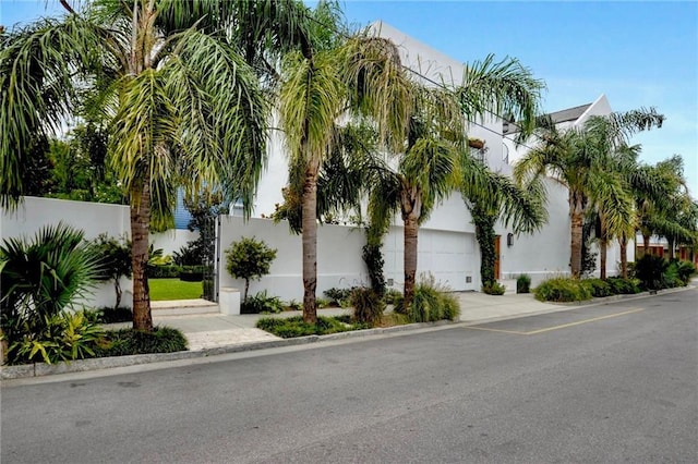 exterior space featuring a garage, stucco siding, and fence