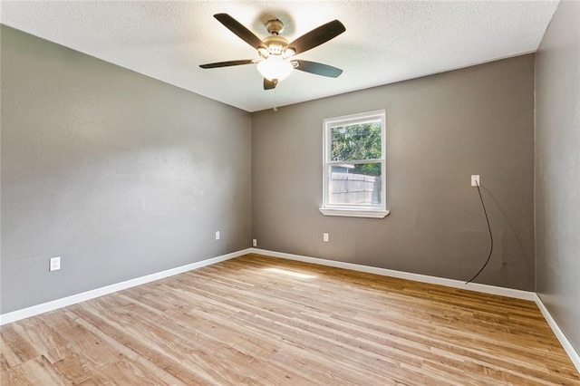 spare room with a textured ceiling, light wood-type flooring, and ceiling fan