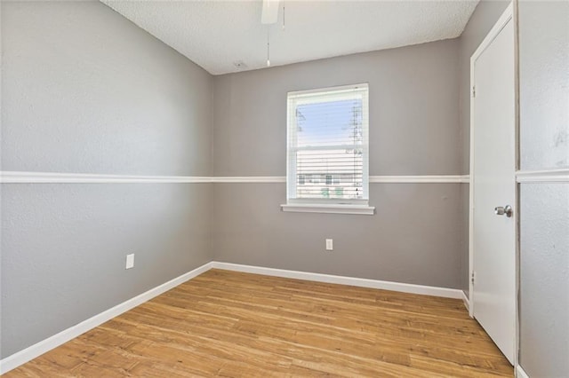 unfurnished room featuring a textured ceiling and light wood-type flooring