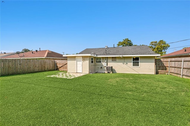 rear view of house with a lawn and central AC unit