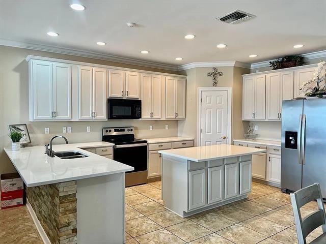 kitchen with white cabinetry, kitchen peninsula, sink, and appliances with stainless steel finishes