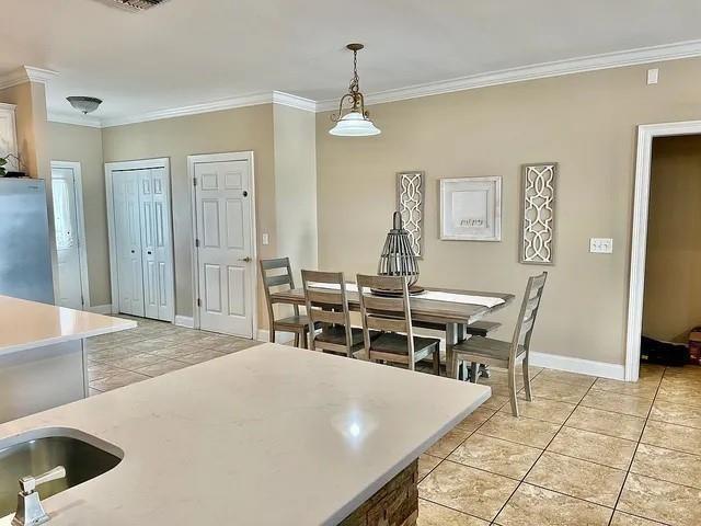 dining area with crown molding and light tile patterned flooring