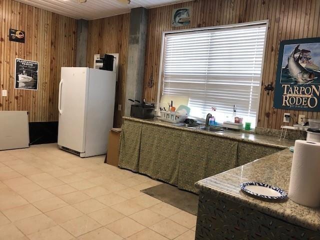 kitchen featuring wood walls and white fridge