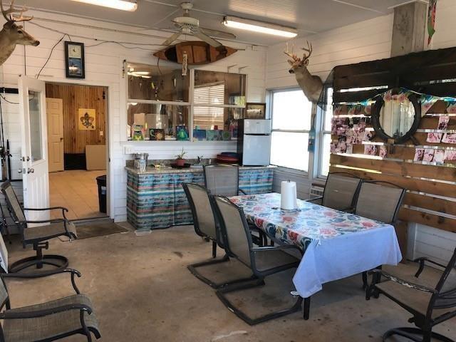 dining area with wood walls and ceiling fan