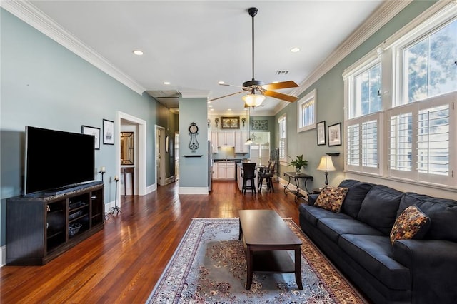 living room with dark hardwood / wood-style floors, crown molding, and a healthy amount of sunlight