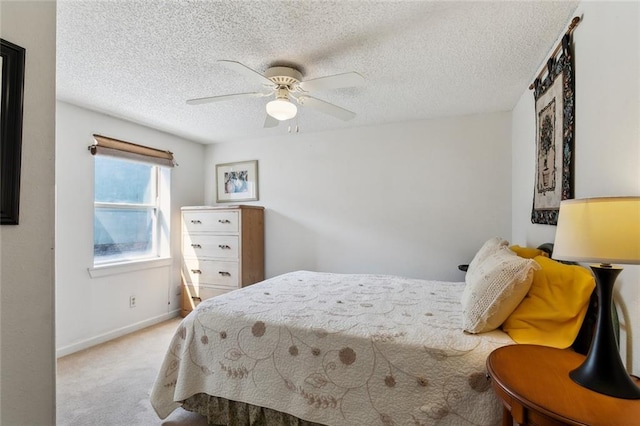 bedroom featuring light colored carpet, a textured ceiling, and ceiling fan