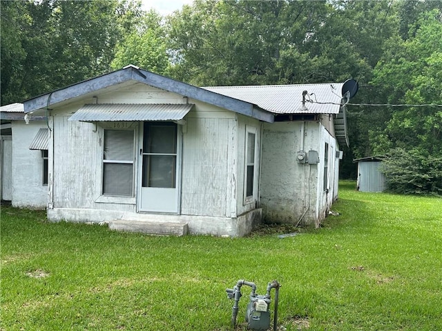 view of side of home with a yard