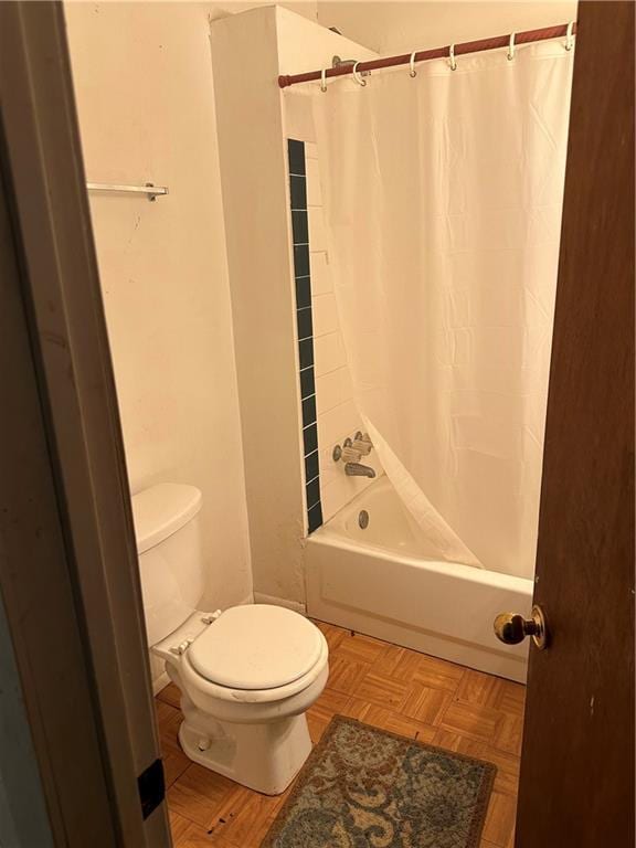 bathroom featuring toilet, parquet floors, and shower / bath combination with curtain