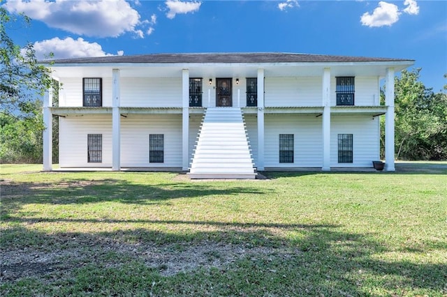 back of house with a balcony and a lawn