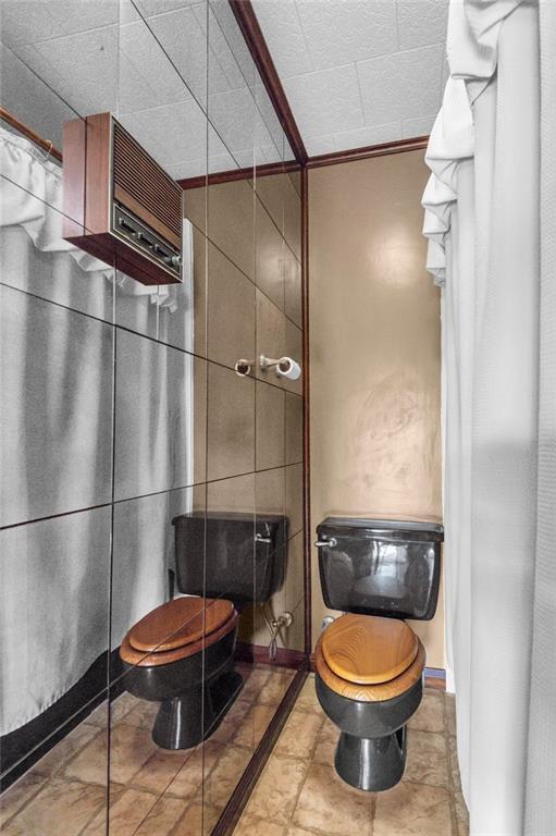 bathroom featuring crown molding and toilet