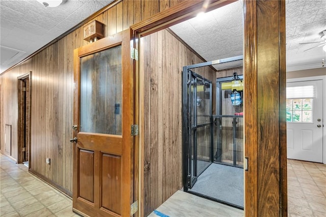 hall featuring wooden walls and crown molding