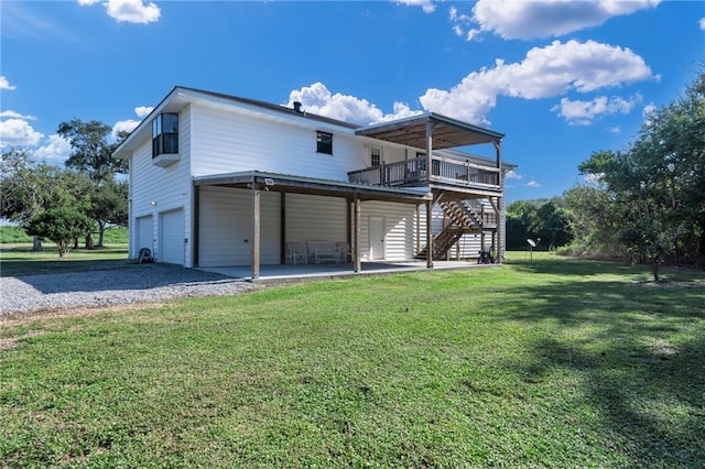 rear view of property featuring a wooden deck, a lawn, and a patio area