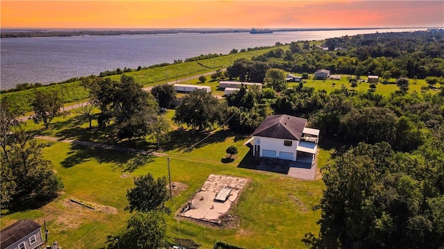 aerial view at dusk featuring a water view