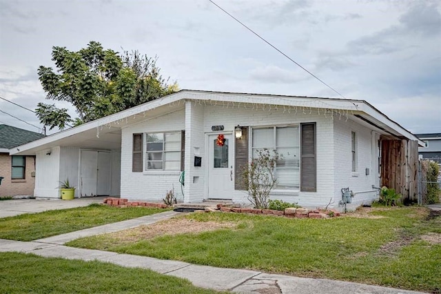 view of front of home with a front yard and a carport