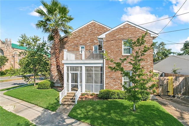 view of front property with a front yard and a balcony