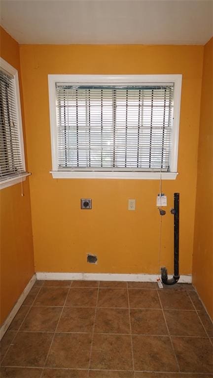 clothes washing area featuring dark tile patterned floors