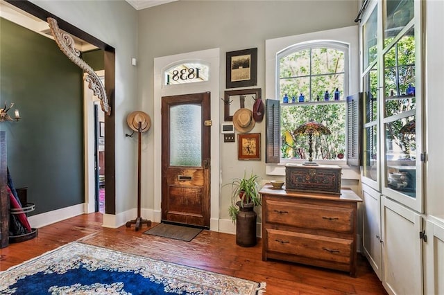 foyer entrance featuring baseboards and wood finished floors