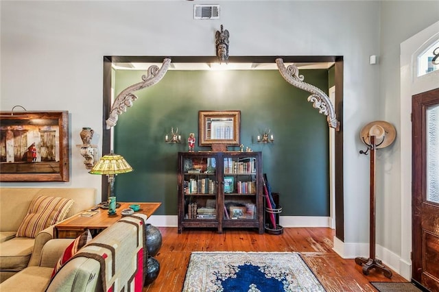 living area featuring visible vents, baseboards, and wood finished floors