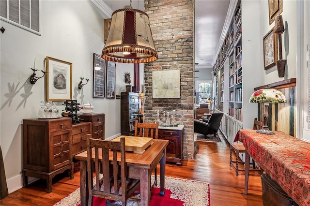 dining area with ornamental molding, visible vents, baseboards, and wood finished floors